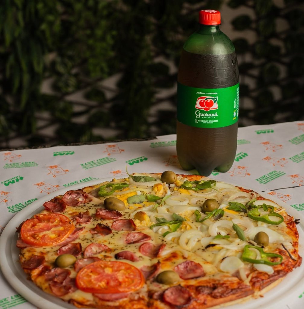 Pizza meio a meio com calabresa, tomate, cebola e pimentão acompanhada de guaraná