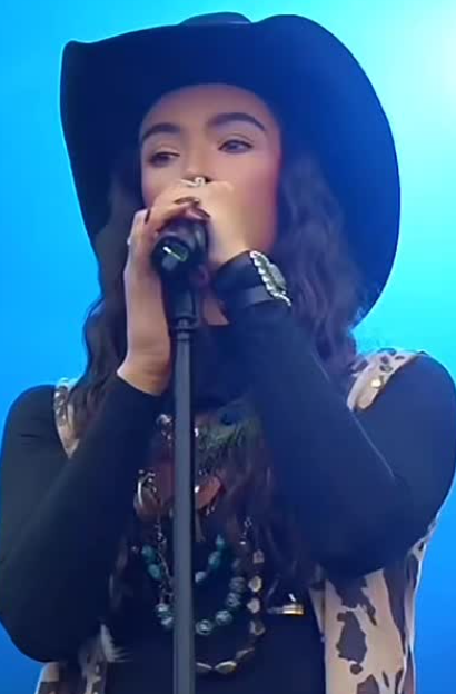 Camryn Marie performing on stage in blue lighting