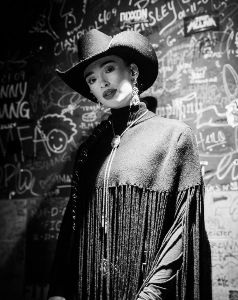 Black and white portrait of Camryn Marie in fringe and bolo tie