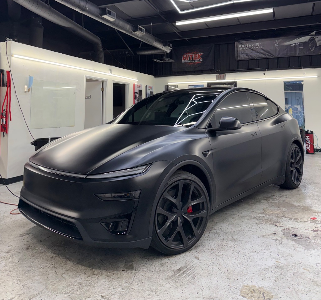 Matte black Tesla Model Y with PPF inside the Royal Window Tint detailing bay