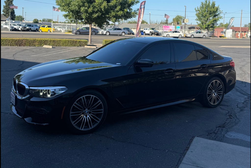Black BMW sedan with tinted windows parked outdoors