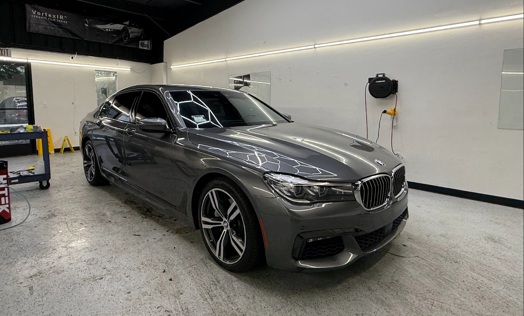 Dark grey BMW 7-series sedan with ceramic film inside the Royal Window Tint shop