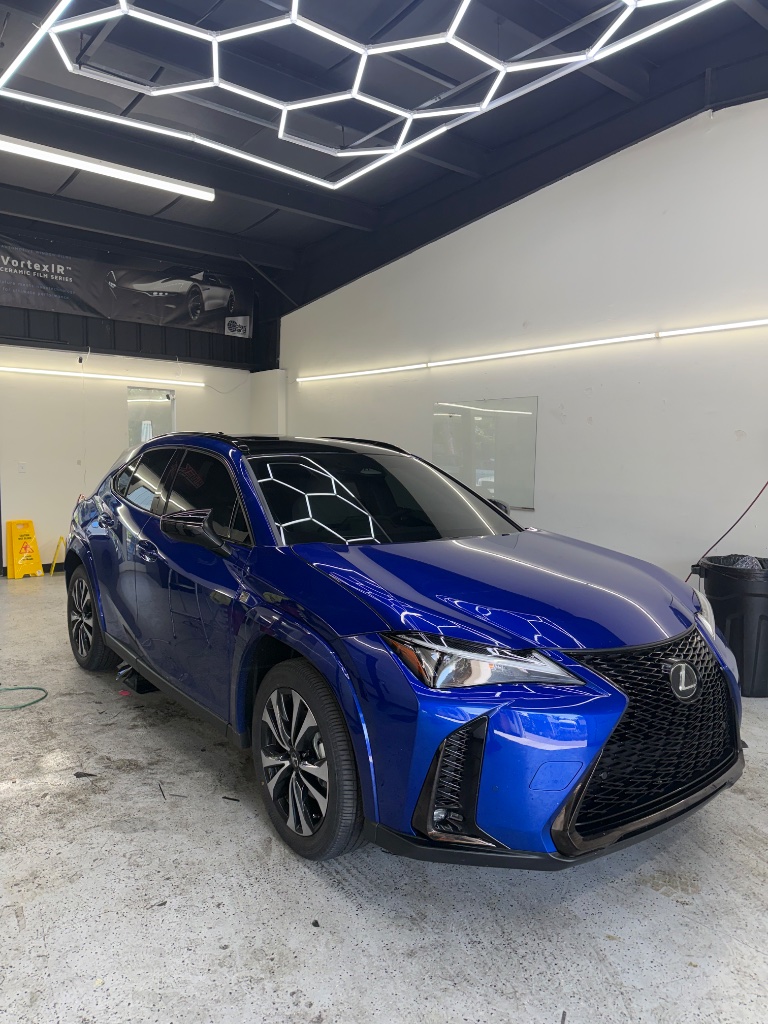 Royal blue Lexus SUV with tinted windows and ceramic film inside the shop