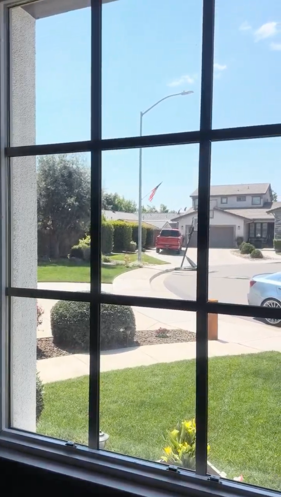 Interior view looking out through a residential tinted window showing a clear bright view of the street