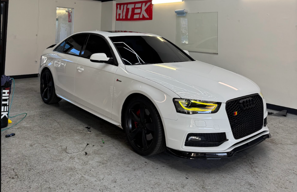 White Audi sedan with tinted windows inside the Royal Window Tint shop