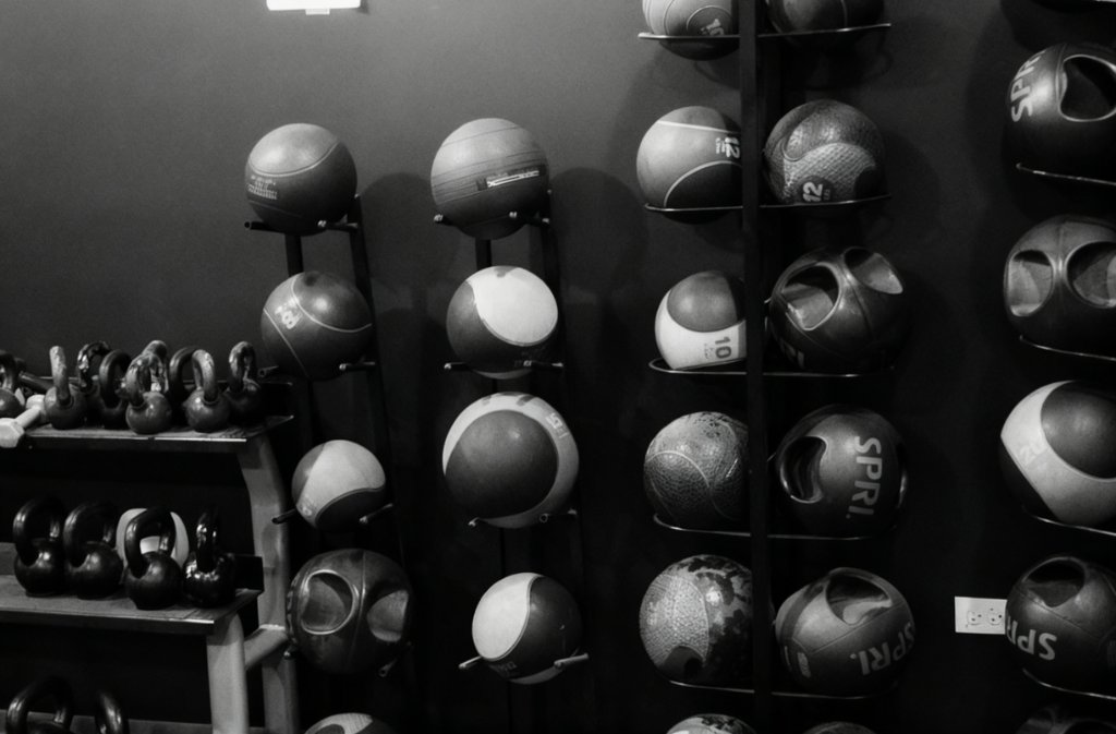 Wall racks holding medicine balls, slam balls, and kettlebells