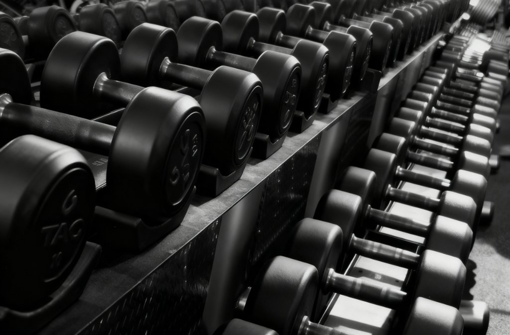 Close-up of a tiered dumbbell rack with neatly aligned hex weights