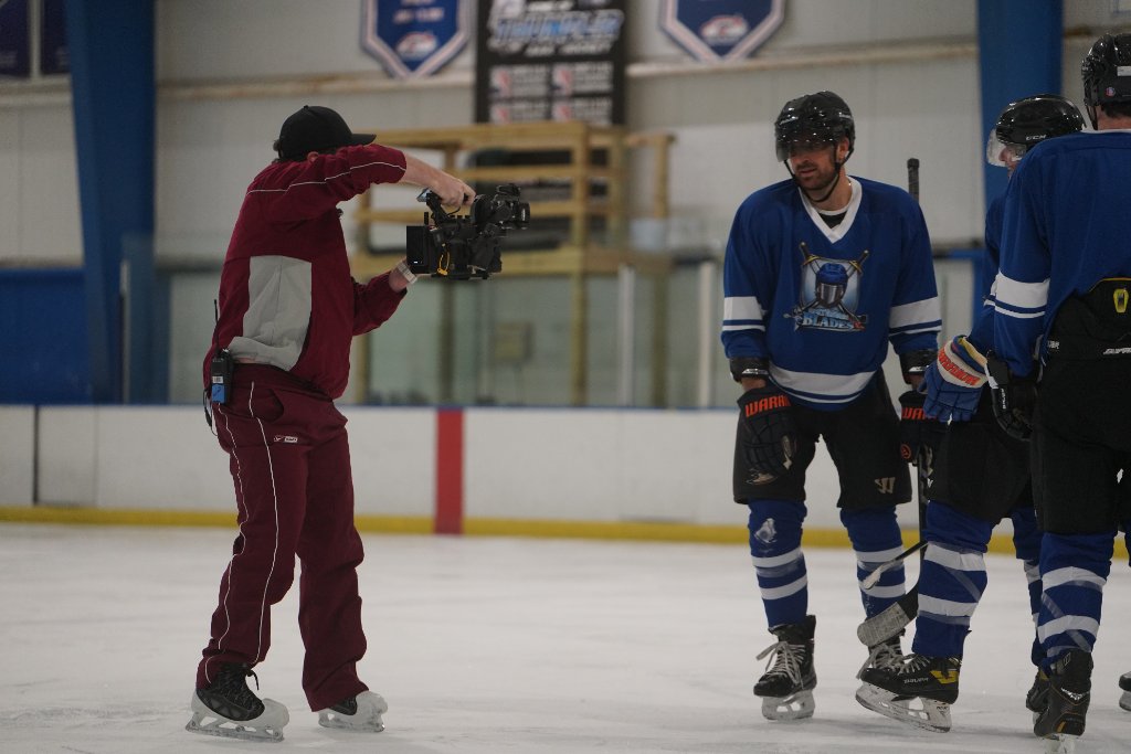 Cinematographer skating on ice with camera
