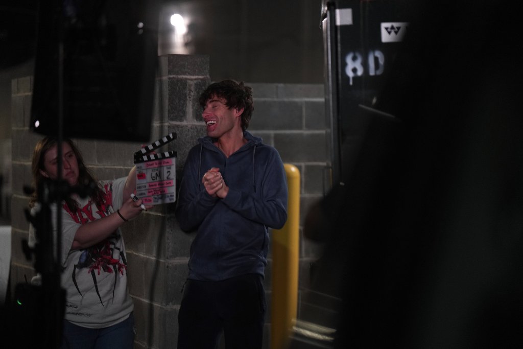 Actor laughing with clapper on set