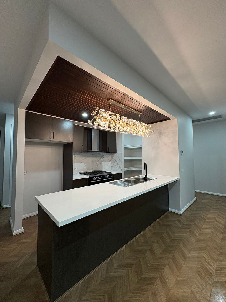 Completed kitchen with island, marble splashback and herringbone flooring after a final builders clean in Melbourne