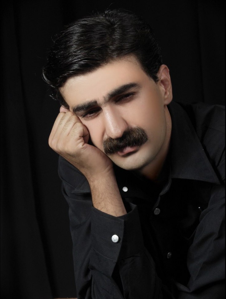 پرتره هنری حمید حمیدی با پس‌زمینه تیره