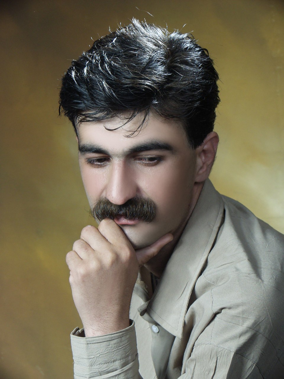 پرتره حمید حمیدی با پیراهن کرم‌رنگ