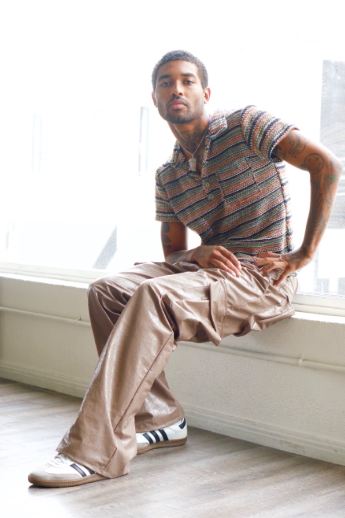 Forest Ripperton seated on window ledge in striped polo