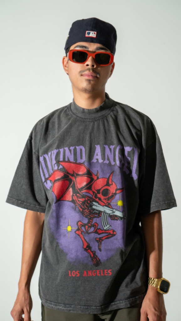 Fashion model in Unkind Angels graphic tee with red sunglasses and MLB cap