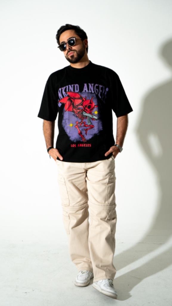 Male model in black graphic tee and cream cargo pants, studio shoot