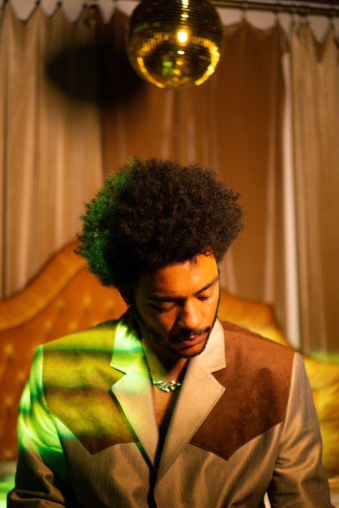 Felix Ames in two-toned western jacket with disco ball above