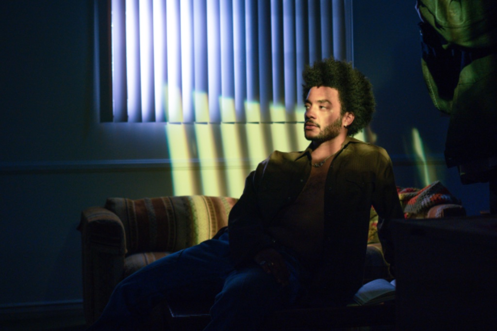 Felix Ames on sofa with vertical light streaks from blinds