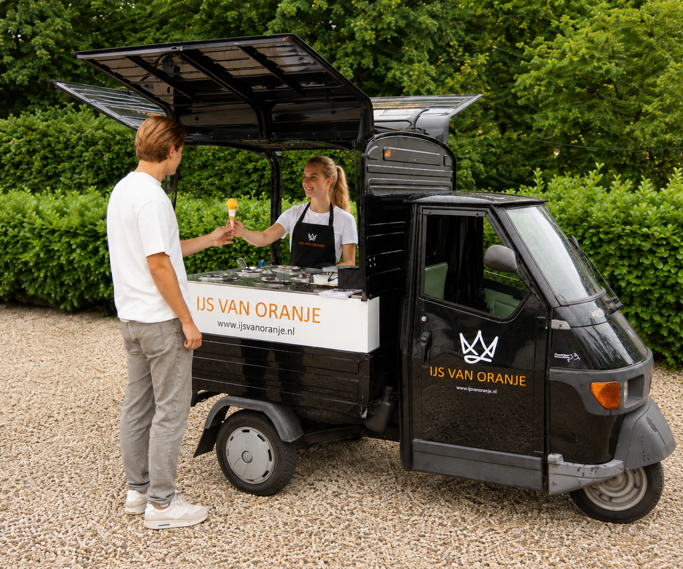 IJs van Oranje medewerker reikt een ijsje uit aan een bezoeker op evenement