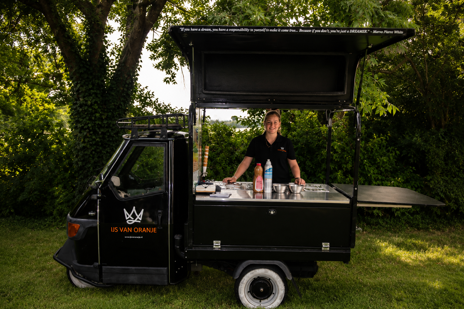 Zwarte IJs van Oranje-tuktuk met medewerker op locatie