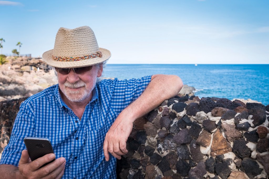 Retired traveler with a straw hat by the Philippine ocean