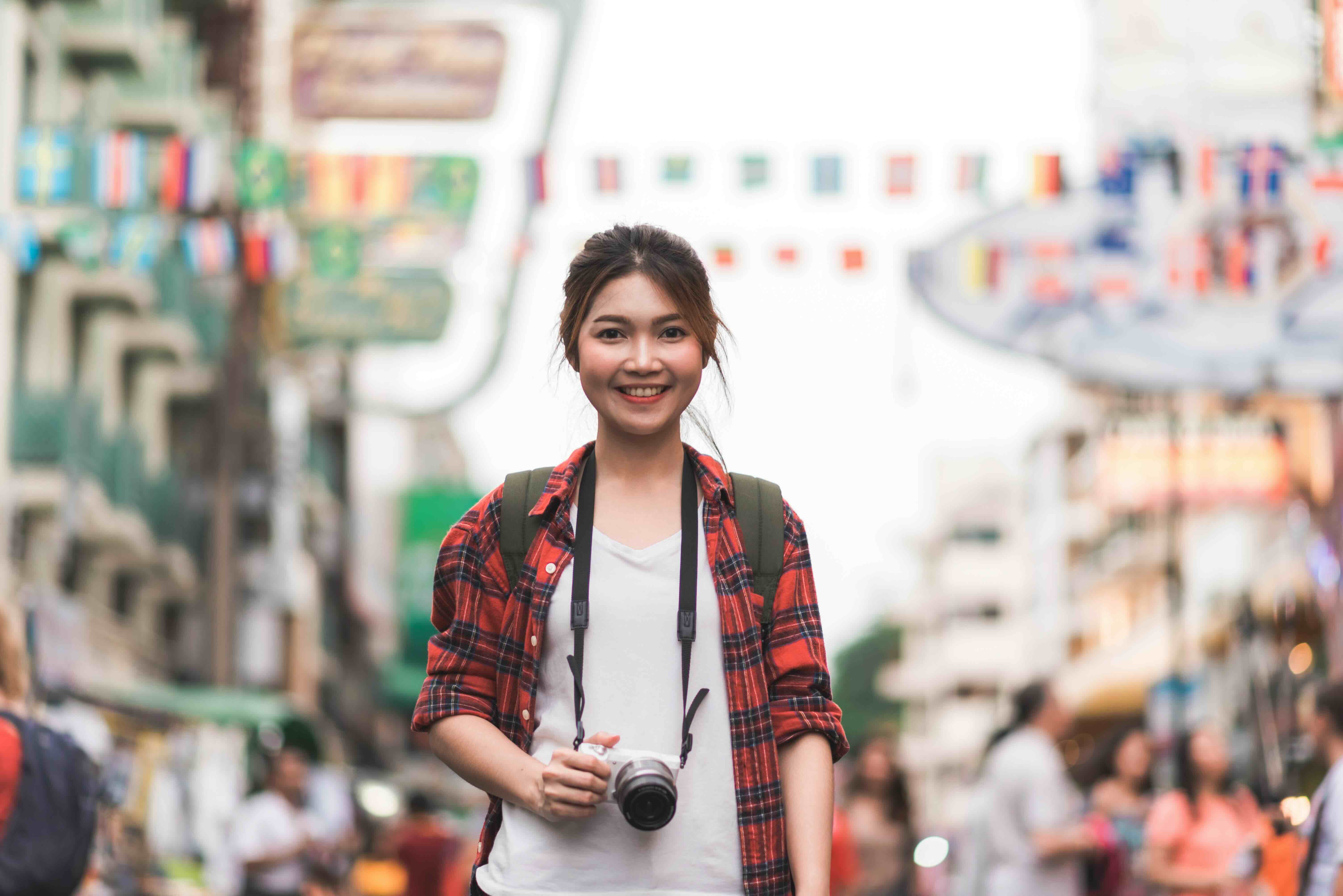 Backpacker woman traveling through a bustling Asian street market