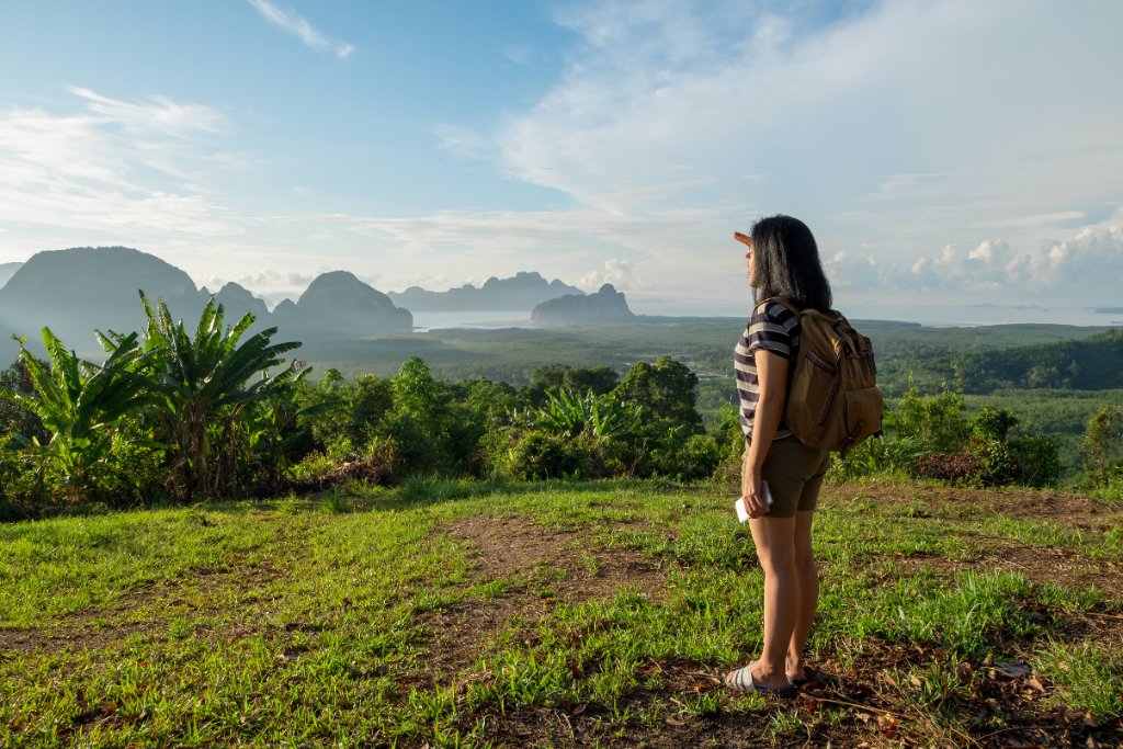 Traveler with backpack enjoying a panoramic tropical mountain view