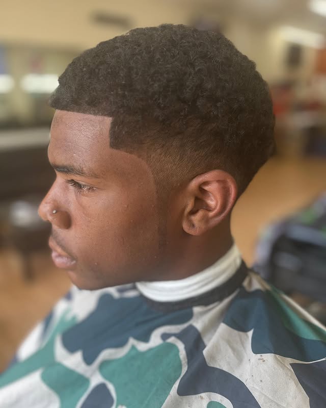 Low fade with natural curly top at Greene's Barber Service