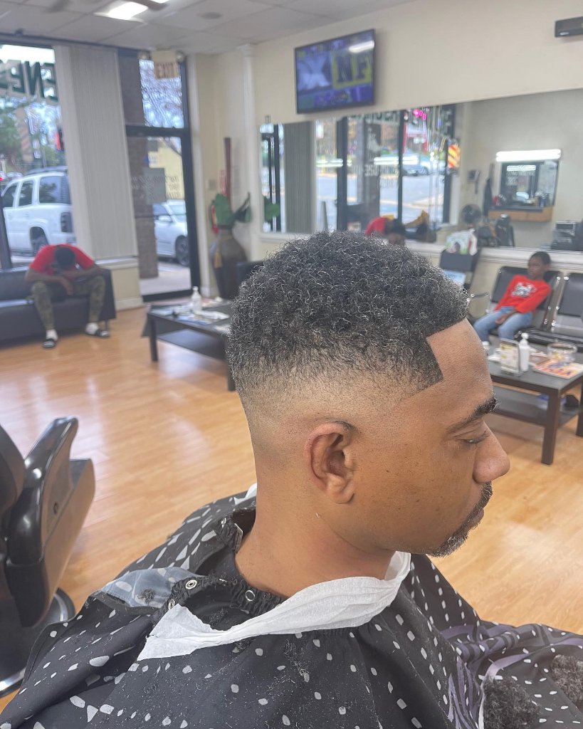 Low taper fade with natural curl at Greene's Barber Service