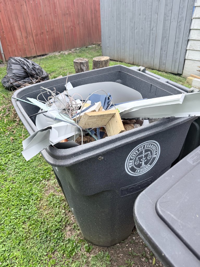 Heavy-duty bin filled with construction debris and household junk for removal