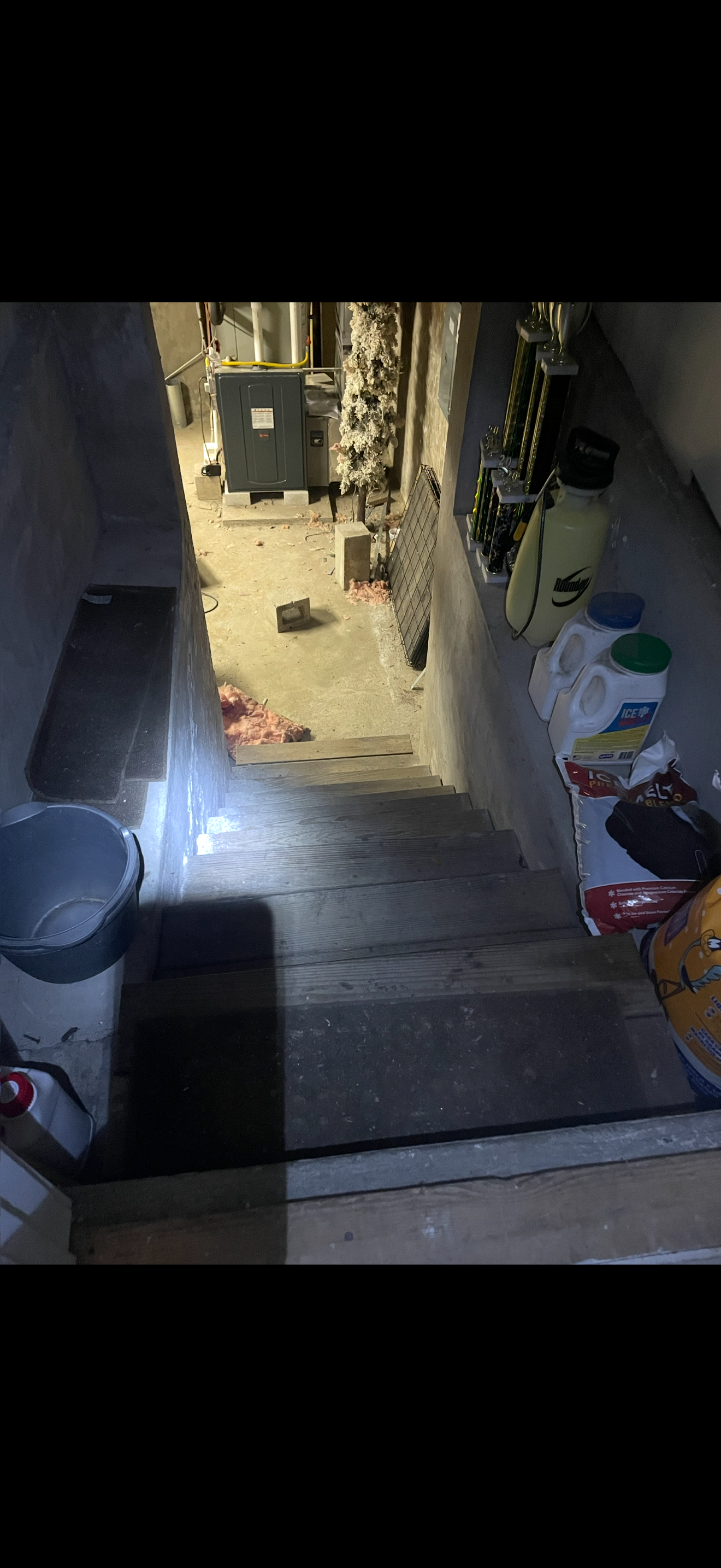 Basement staircase cluttered with debris before cleanout