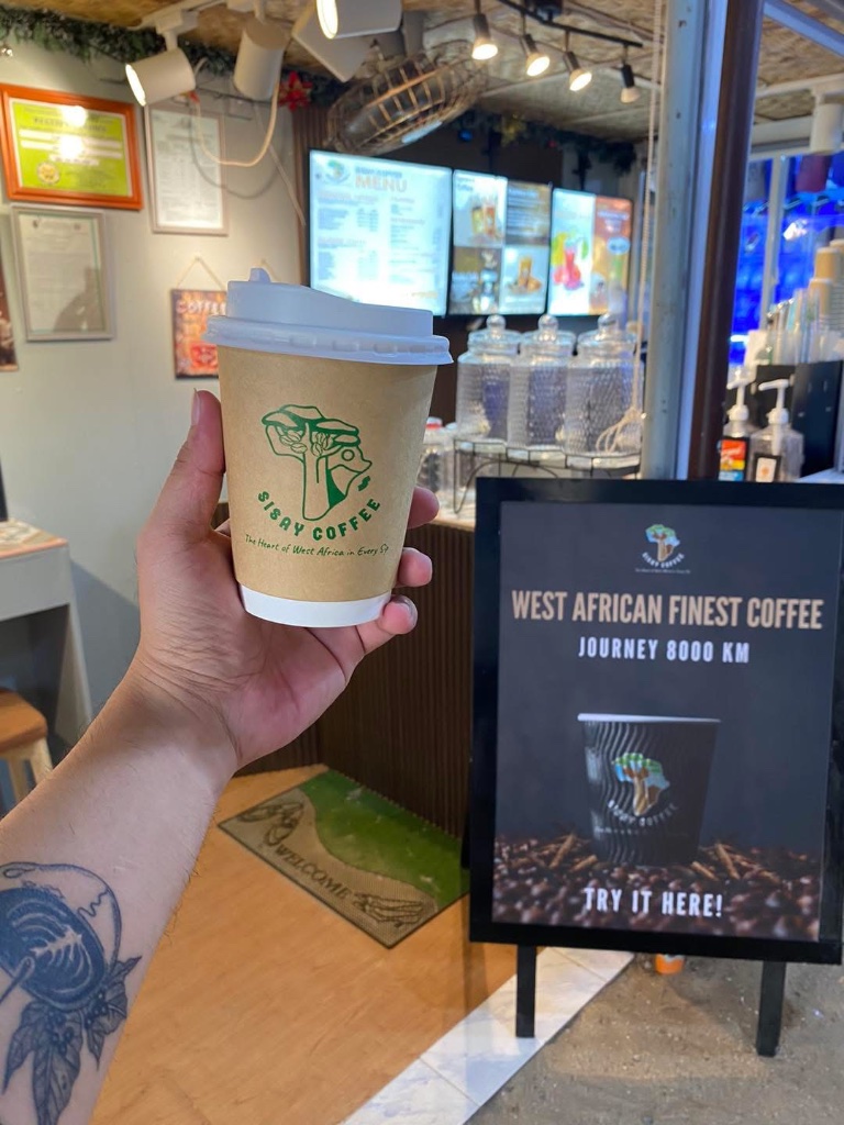 Customer holding a Sisay Coffee cup inside the Boracay shop