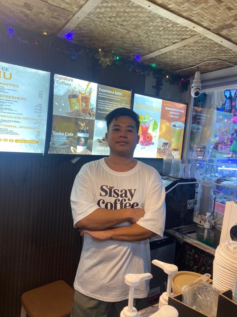 Sisay Coffee barista wearing the brand t-shirt behind the counter in Boracay