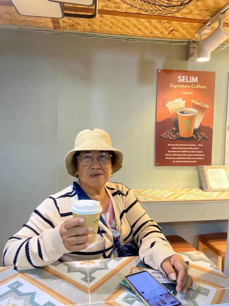 Guest holding a Sisay Coffee cup at the Boracay shop