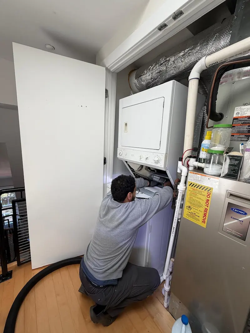 Dryer Repair Medic technician repairing a stacked clothes dryer in a Northern Virginia home