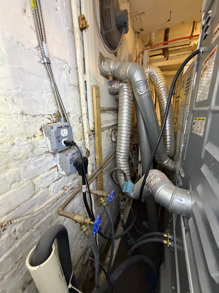 Technician servicing a compact dryer installed in a closet with vent hose