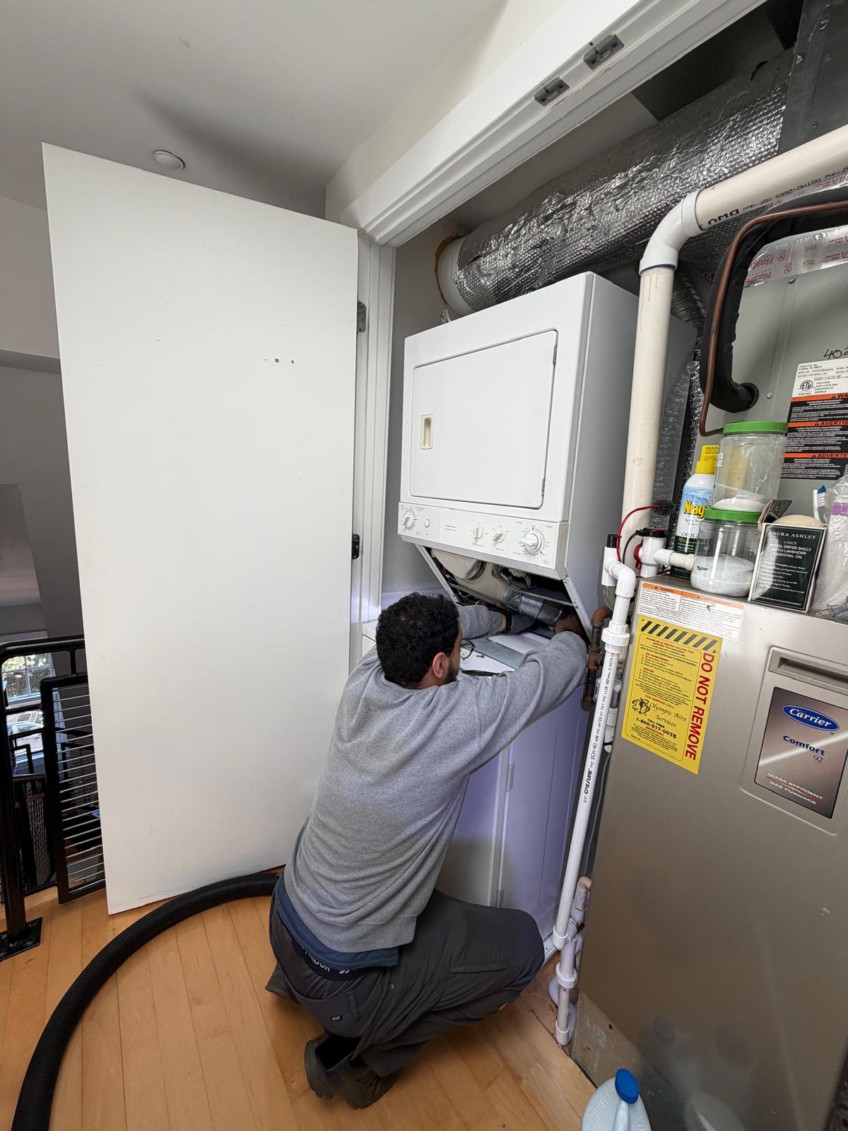 Dryer Repair Medic technician repairing a stacked clothes dryer in a Northern Virginia home