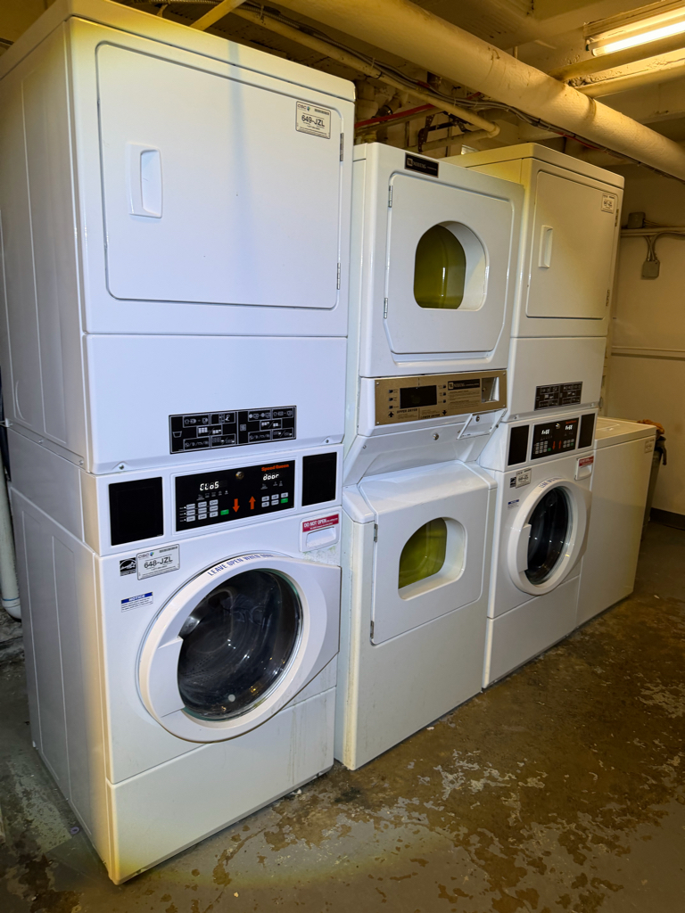Technician reaching into a closet-mounted dryer to perform a repair