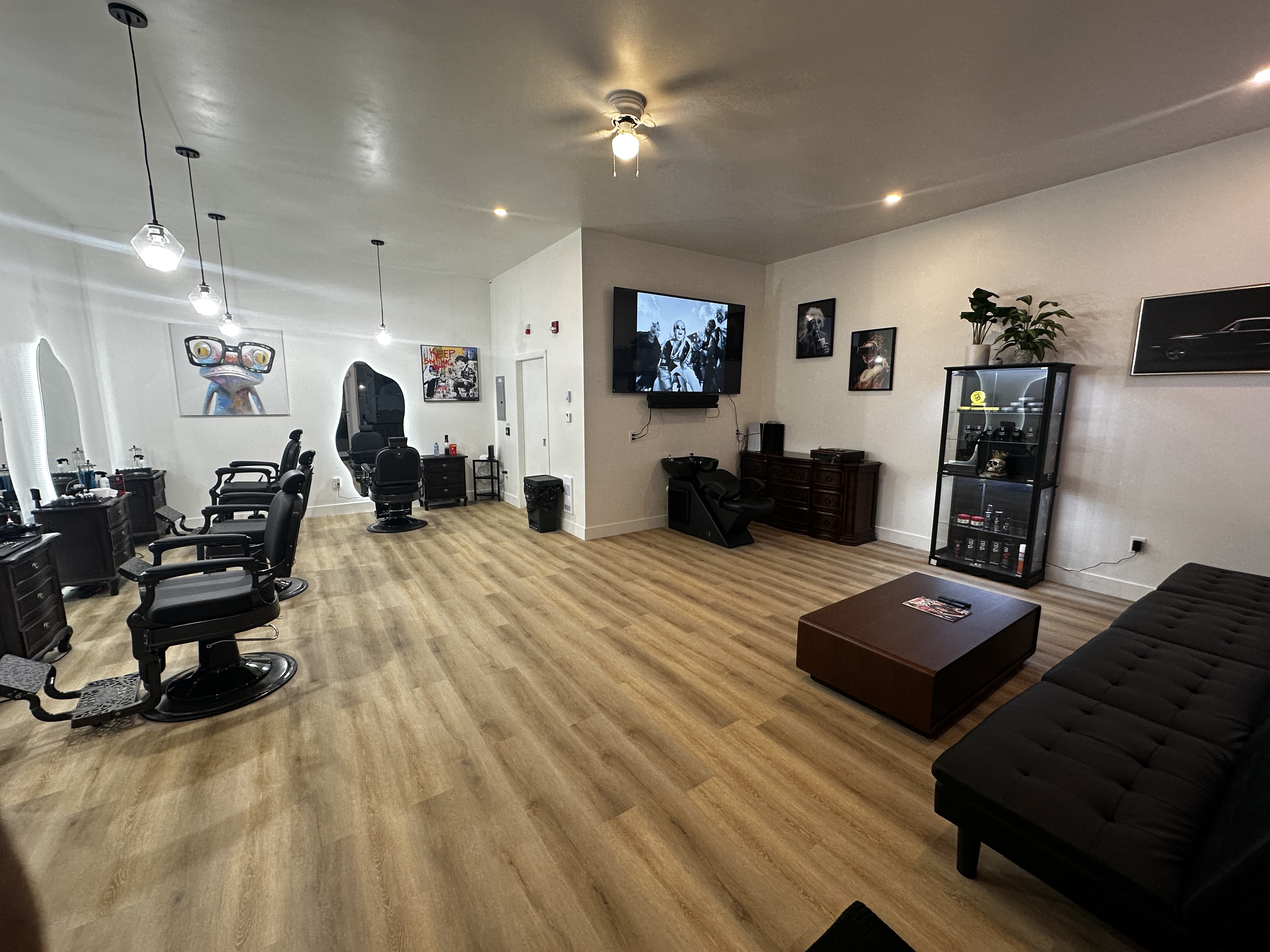 Interior of Bros Barber - four vintage barber chairs in a dark luxury space with industrial pendant lights and exposed brick