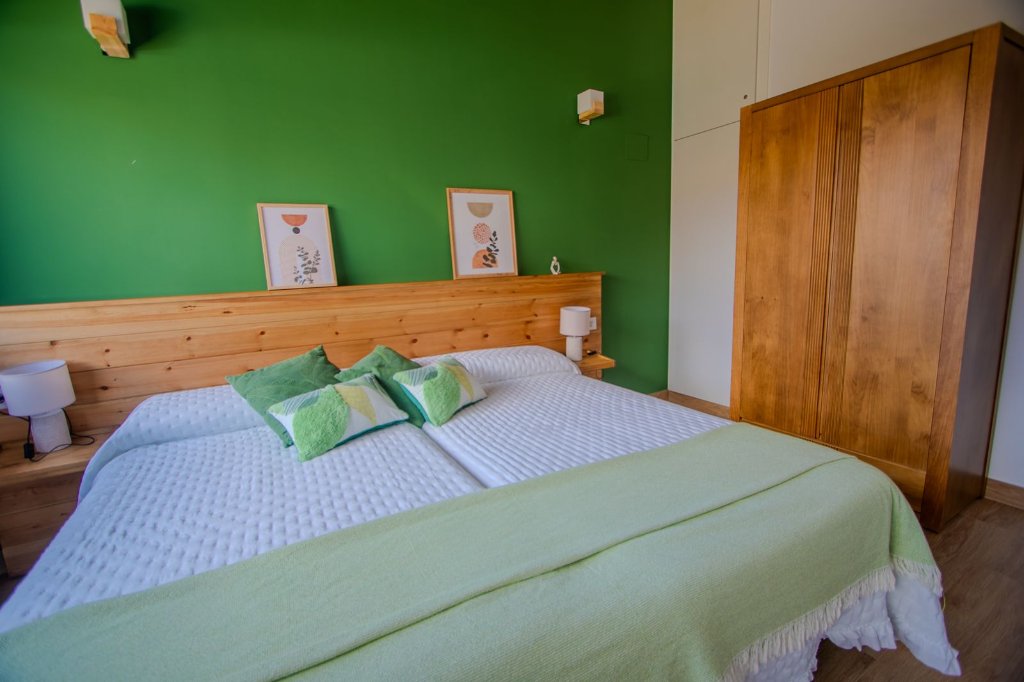 Dormitorio con pared verde