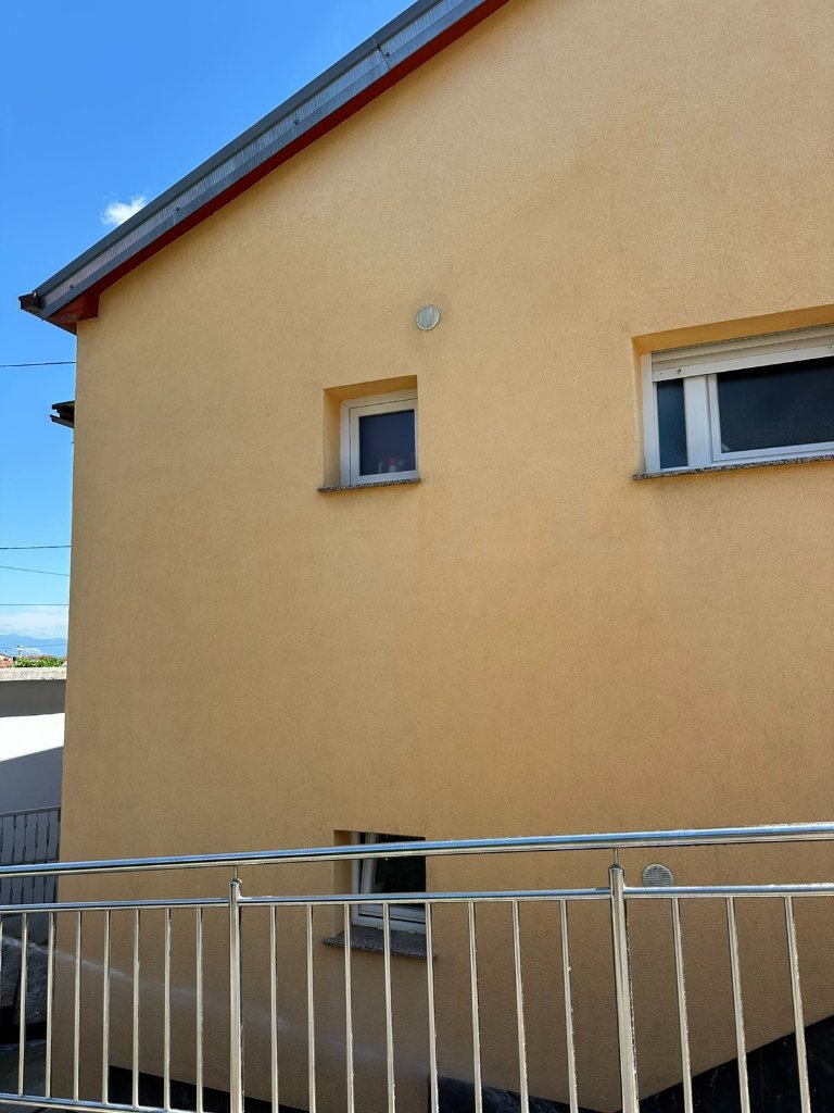 Žuta fasada stambene zgrade s prozorima
