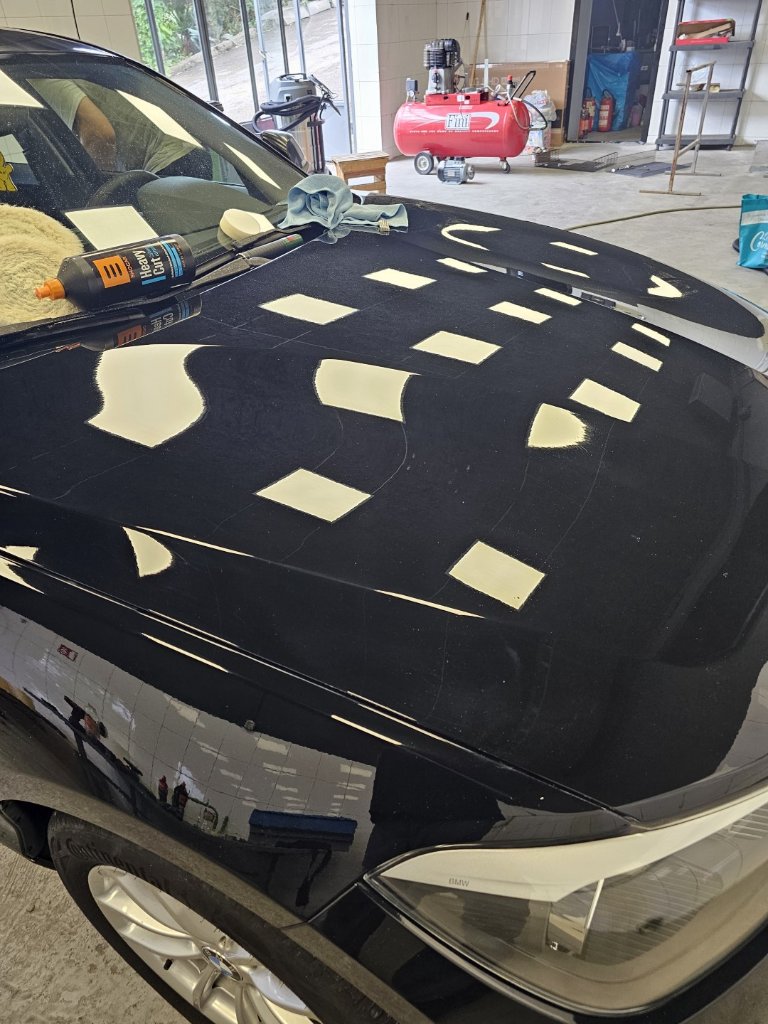 Poliranje crne BMW haube s mjernom mrežom za korekciju laka