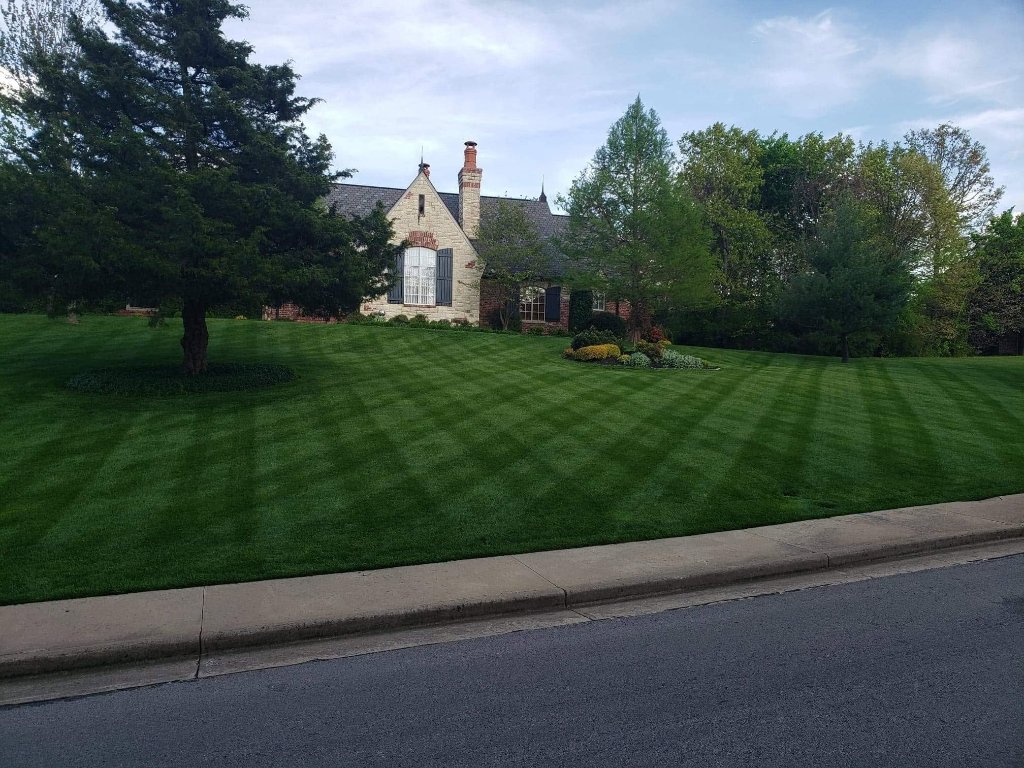 Stone home with perfect diagonal lawn stripes