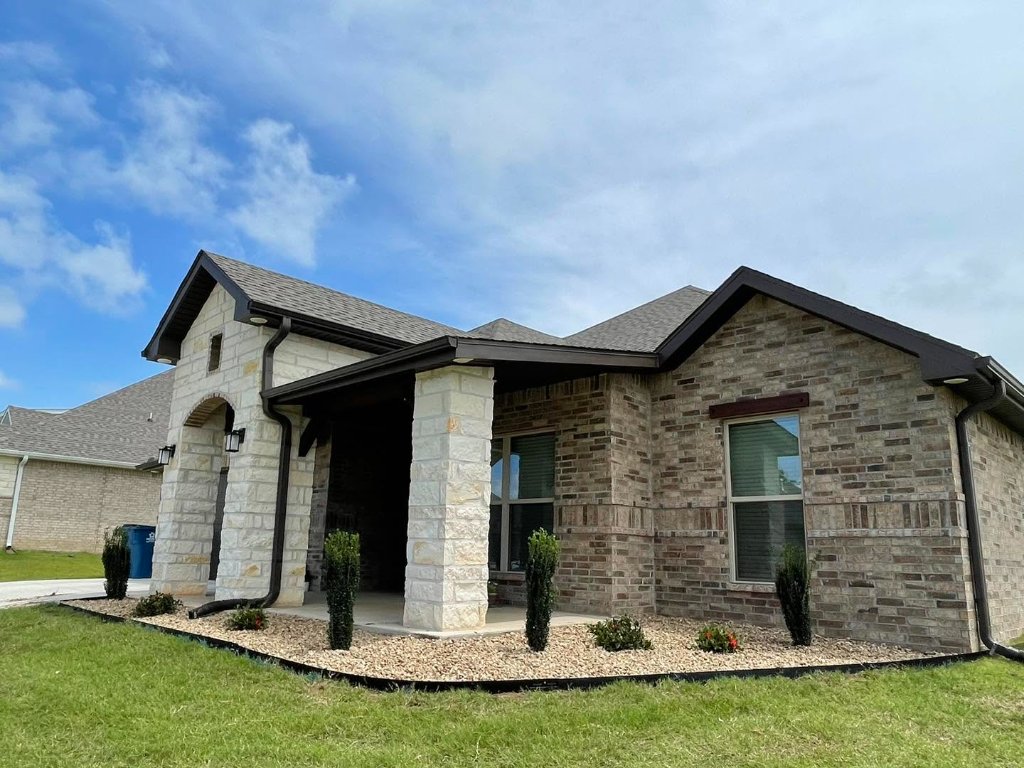 New home landscape installation with black mulch and shrubs