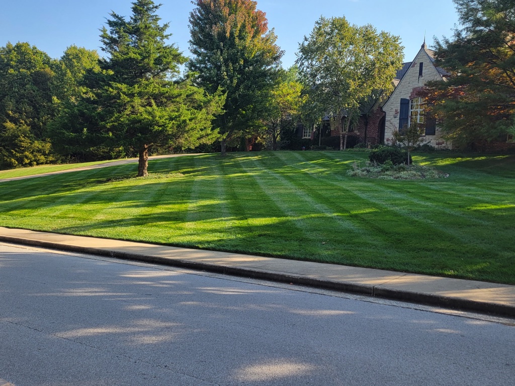 Mower and trailer on large estate striped lawn