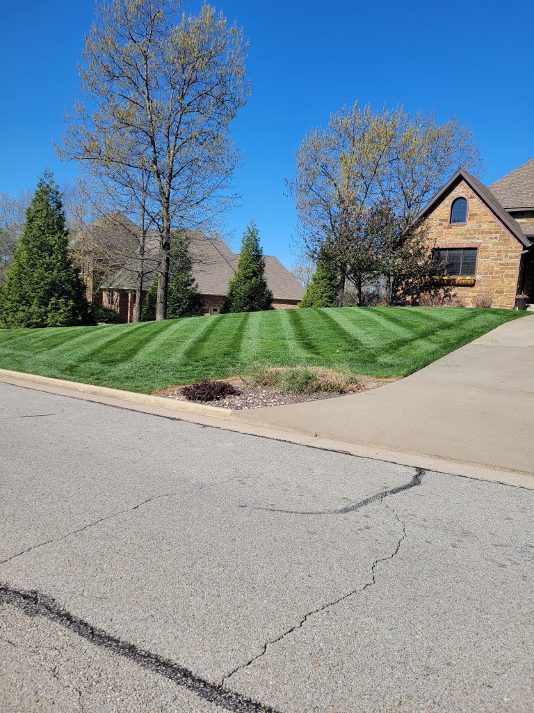 Perfectly striped estate lawn with driveway curve
