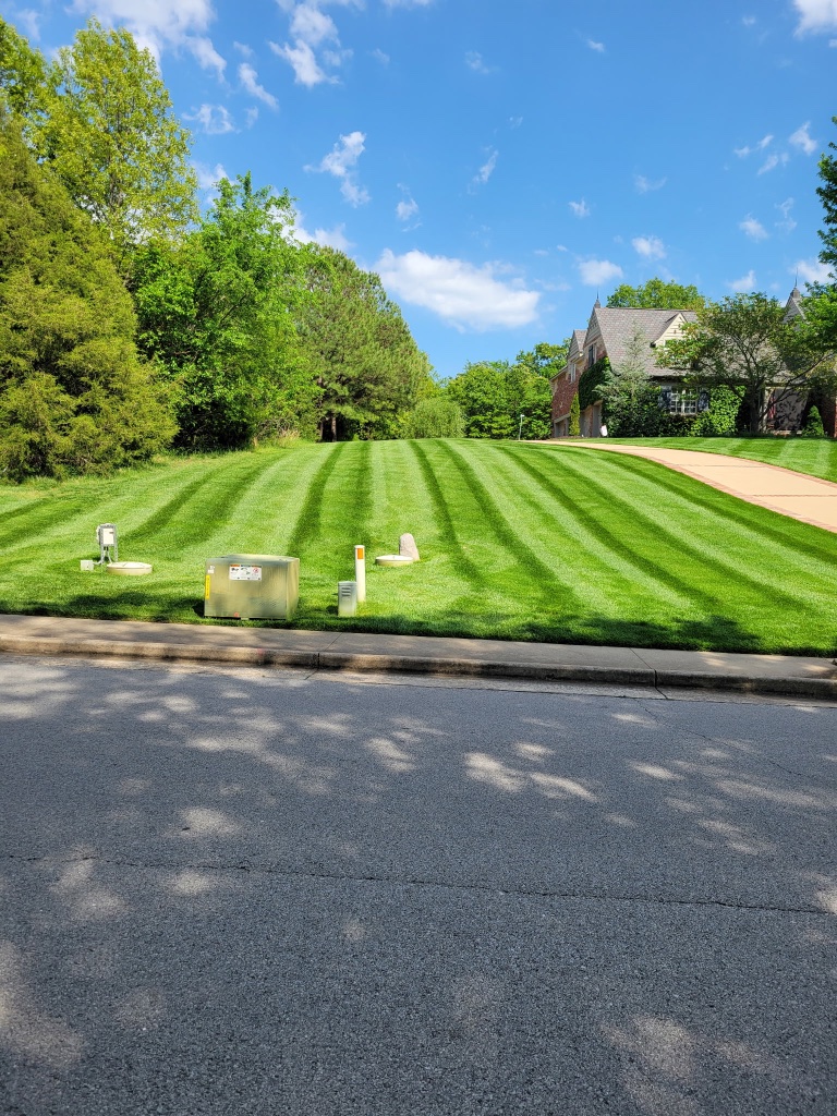 Estate home with formal boxwood hedge garden and patio