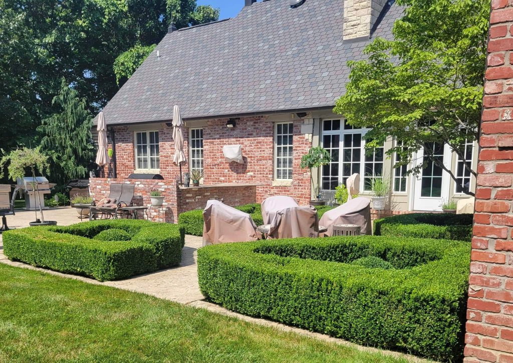 Estate home with precisely trimmed boxwood hedges