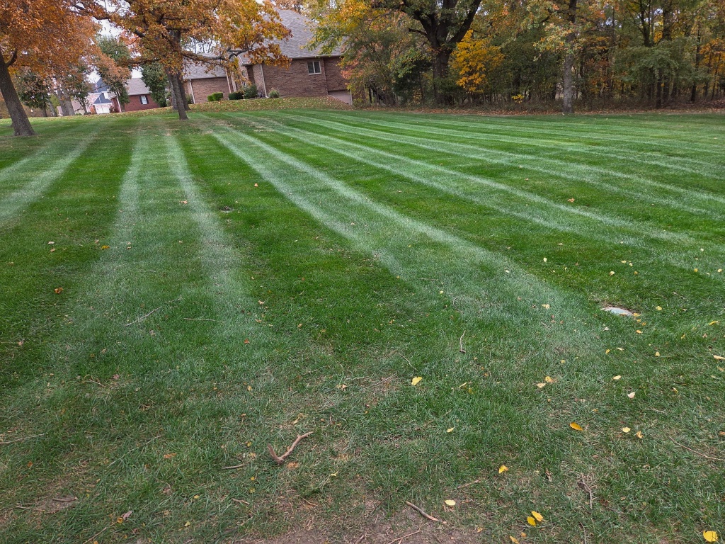 POV from yellow mower over striped lawn