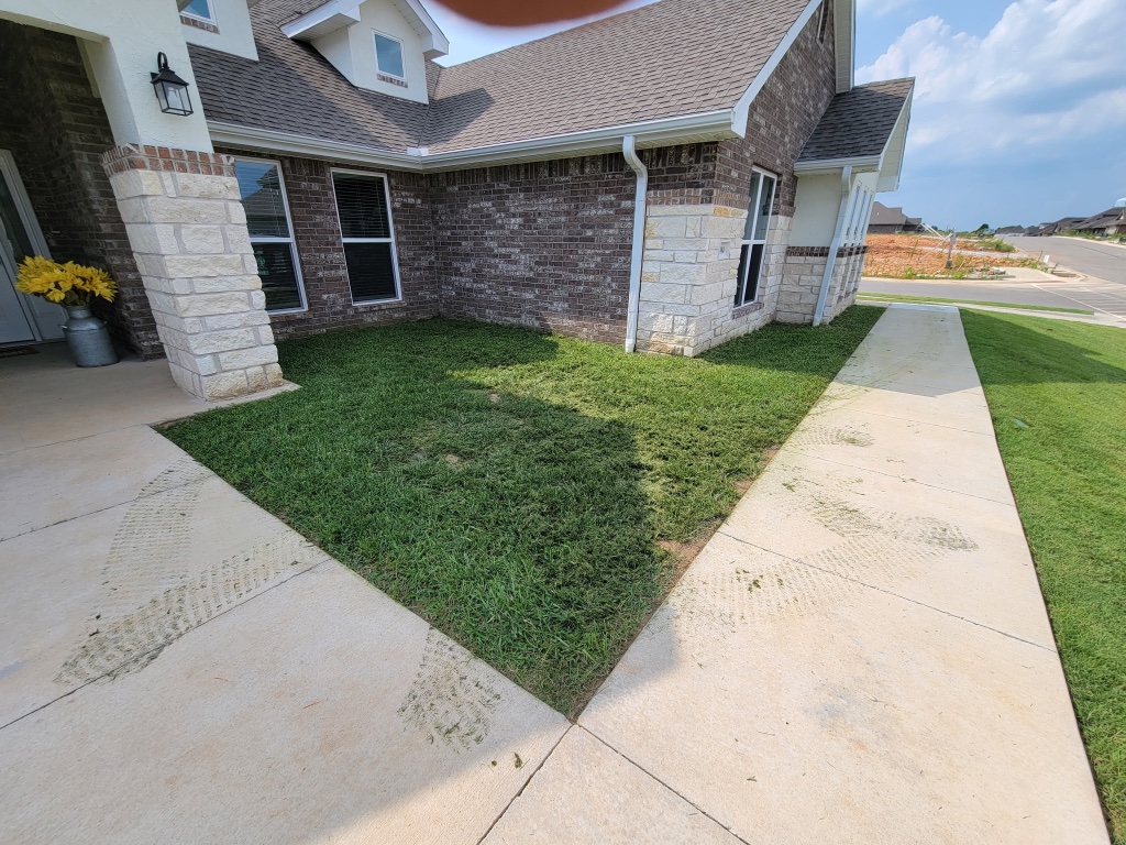 Stand-on mower on striped lawn with American flag