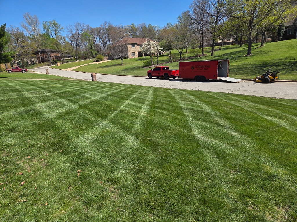 Large brick estate home with cross-hatch mowed lawn